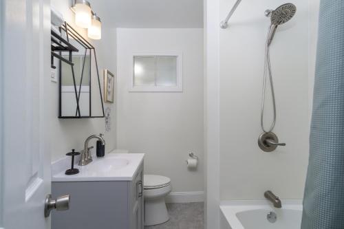 a white bathroom with a sink and a toilet at Nomad Retreat Pet-Friendly, Hot Tub & Mountain View in Old Fort