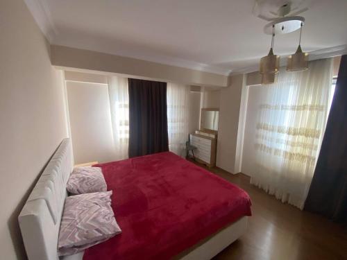 - une chambre avec un grand lit et une couverture rouge dans l'établissement MUSTAFA KEMALPASA MEH. DEMIRÖZ SK NO: 8/10 ARNAVUTKÖY/ IST, à Arnavutköy