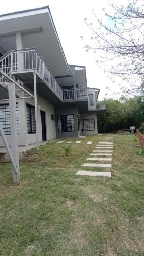 Una gran casa blanca con una escalera en el patio en Abeli Aparts en San José