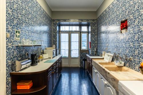 a large kitchen with blue and white wallpaper at Douro D'Heart - Regua Guesthouse - Casa Completa in Peso da Régua