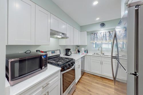 a kitchen with white cabinets and a stove top oven at Beachwalk Condominiums 6F in Panama City Beach
