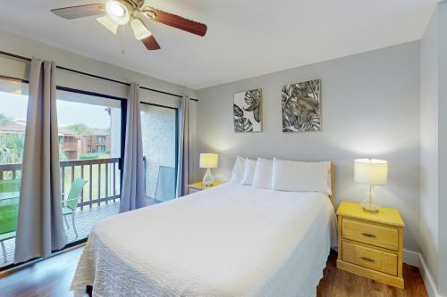 a bedroom with a bed and a balcony at Beachwalk Condominiums 6F in Panama City Beach