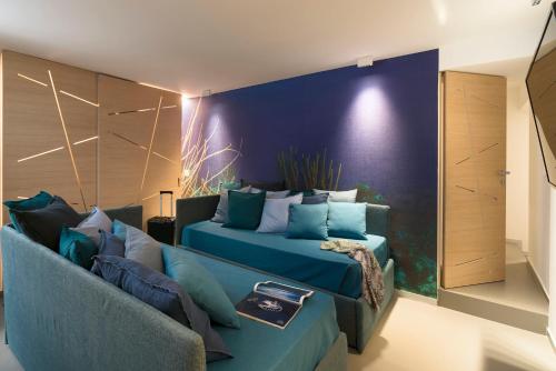 a living room with a couch and a blue wall at Duomo Suites & Spa in Catania