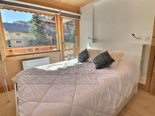 a bedroom with a bed and a large window at Appartement Méribel, 3 pièces, 6 personnes - FR-1-182-243 in Les Allues