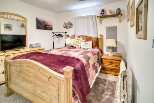 una camera con letto in legno e TV di Sylvan Cabin on 73 Acres - Pond On-Site! a Sylvania