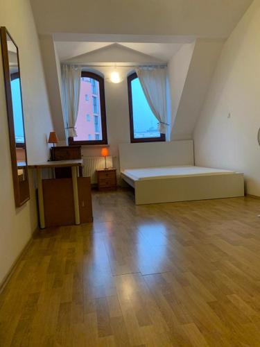 Großes Zimmer mit einem Bett und zwei Fenstern in der Unterkunft Spacious 2-rooms penthouse in Warsaw city center in Warschau