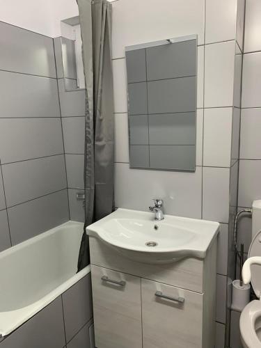 a white bathroom with a sink and a mirror at Cazare barlad in Bîrlad