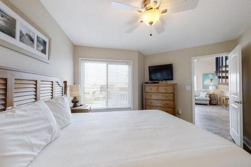a bedroom with a white bed and a ceiling fan at Plantation West Resort III in Gulf Shores
