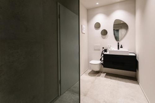 a bathroom with a sink and a toilet and a mirror at Exklusive Design Appartement Magnolia Neubau in Pfungstadt