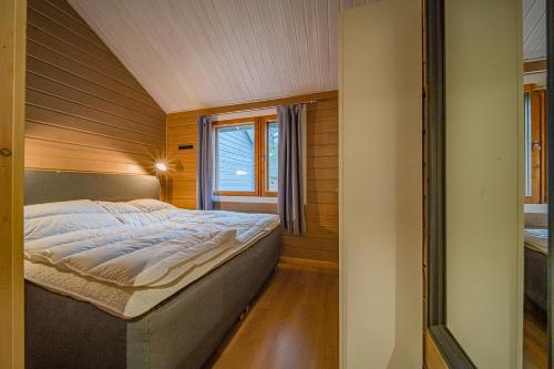 a bed in a small room with a window at Levillas Lammaskuru A in Levi