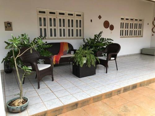 a room with a bed and chairs and plants at Casa com 4 quartos e área externa com jardim in São Raimundo Nonato