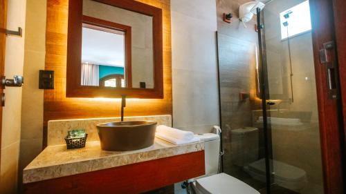 a bathroom with a sink and a toilet and a mirror at Flores da Praça in Morro de São Paulo