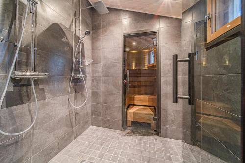 uma casa de banho com um chuveiro e uma cabina de duche ao nível do chão em Levillas Lammaskuru A em Levi