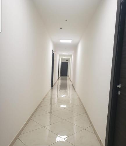 an empty hallway with white walls and a tile floor at max hotel e restaurant in Pontecagnano