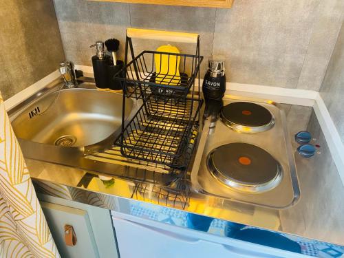 a kitchen sink with a dish drying rack next to it at Petit cocon proche de Stanislas in Nancy