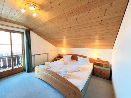 um quarto com uma cama grande e um tecto em madeira em Ferienwohnung Ferienidyll am Forrgensee em Schwangau