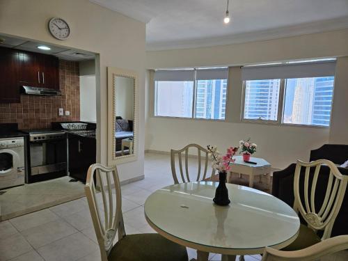 a kitchen and dining room with a table and chairs at Lakeshore Towers, Cluster Y , JLT, 1BHK in Dubai