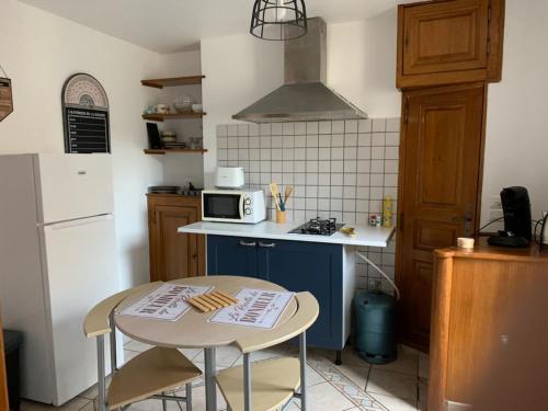 a small kitchen with a small table and a stove at Appartement avec terrasse in Gien
