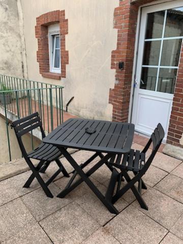 a black picnic table in front of a building at Appartement avec terrasse in Gien