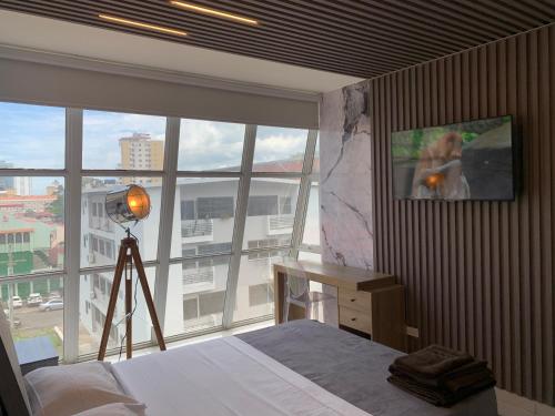 巴拿馬城的住宿－4B - Centríco Divertido FIT 4BR，一间卧室设有一张床和一个大窗户