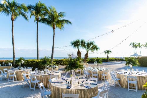 a table set up for a wedding on the beach with palm trees at Sundial Beach Resort & Spa in Sanibel