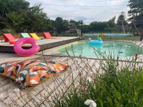 une piscine avec des gonflables colorés et un parc aquatique dans l'établissement gîte la vie en couleur 14 personnes, à Saint-Paul-en-Gâtine