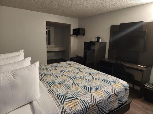 a hotel room with a bed and a flat screen tv at Motel 6 Sacramento CA Natomas in Sacramento