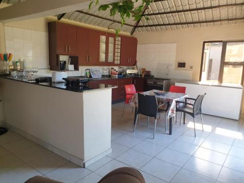 a kitchen with a counter and a table and chairs at Bianca's in Matola