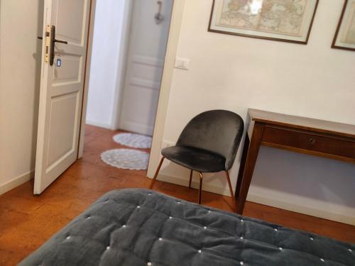 ein Schlafzimmer mit einem Stuhl neben einem Schreibtisch in der Unterkunft Bed&Breakfast Angela in Clusone