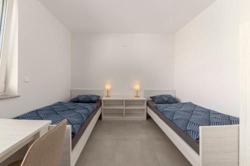 2 Betten in einem weißen Zimmer mit 2 Lampen in der Unterkunft RM Roma Studio in Celje