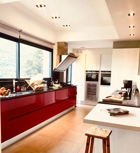 a kitchen with red cabinets and a large window at Villa Hirondelles 35 in Cavalaire-sur-Mer