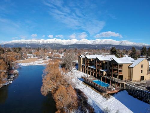 an aerial view of a resort with snow covered mountains at Whitefish Riverfront Hotel in Whitefish