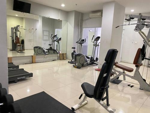 a gym with several exercise bikes in a room at Tamansari Mahogany Apartment By Sagita Residence Karawang in Karawang