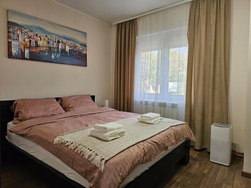 a bedroom with a bed with two towels on it at AeroVista Apartment in Surčin