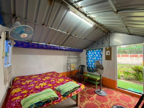巴卡利的住宿－Tapama Resort，卧室配有1张床、风扇和窗户。