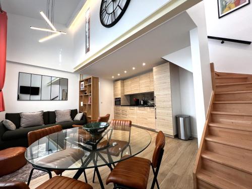 une salle à manger et un salon avec une table en verre dans l'établissement Apollinaire - Luxury Loft - Heart of Montparnasse, à Paris
