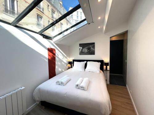 une chambre avec un lit avec deux serviettes dessus dans l'établissement Apollinaire - Luxury Loft - Heart of Montparnasse, à Paris