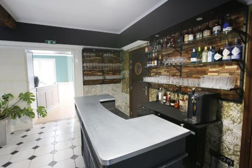 a kitchen with a counter with bottles on the wall at Le Moulin de Saint-Aulaye in Saint-Aulaye