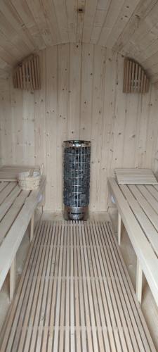 a room with two benches and a trash can at Domki u Łosia Bieszczady & Sauna in Polańczyk