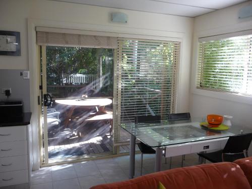 a kitchen with a table and a sliding glass door at Orchard Garden in Old Reynella