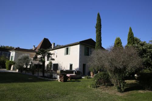 a white house with a tree in the yard at Le Moulin de Saint-Aulaye in Saint-Aulaye