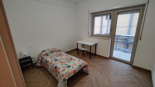 1 dormitorio con cama, mesa y ventana en Locanda del Viaggiatore en LʼAquila