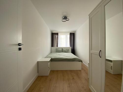 Habitación pequeña con cama y ventana en Apartament FANCY, en Kielce