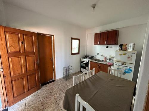 a kitchen with a table and a kitchen with a refrigerator at Departamento 1 dormitorio para 3 personas en Miguel Lanus in Posadas