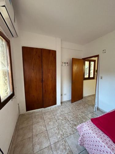 1 dormitorio con puertas de madera y suelo de baldosa en Departamento 1 dormitorio para 3 personas en Miguel Lanus en Posadas