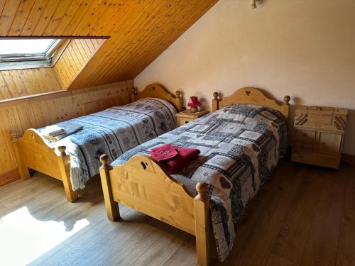 a bedroom with two beds in a attic at L'écho des Artois in Uzelle