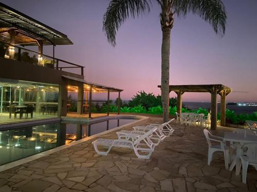 a villa with a swimming pool at night at Hotel Caieiras in Guaratuba