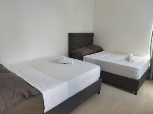two twin beds in a room with a chair at El Encanto casa de descanso in Rivera