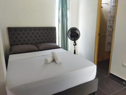 a bedroom with a white bed with a fan on it at El Encanto casa de descanso in Rivera