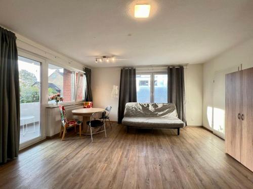 a bedroom with a bed and a table and windows at Work&Stay Apartment - Kiel in Kiel